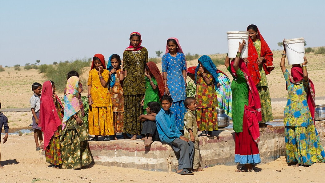Un gruppo di donne in India preleva acqua da un pozzo